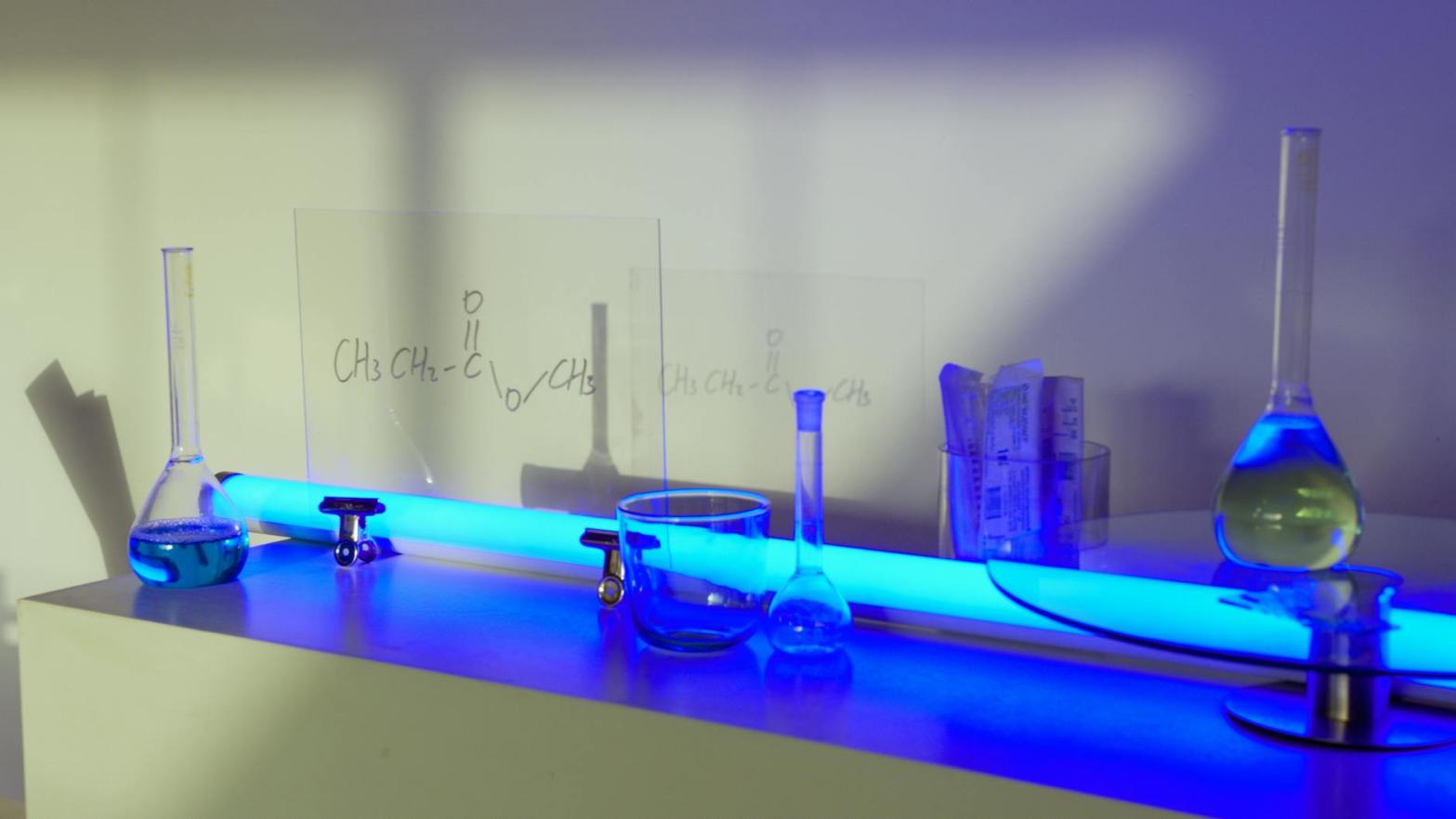 glass containers on a white table with blue light